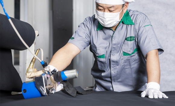 A male worker is cutting the cloth