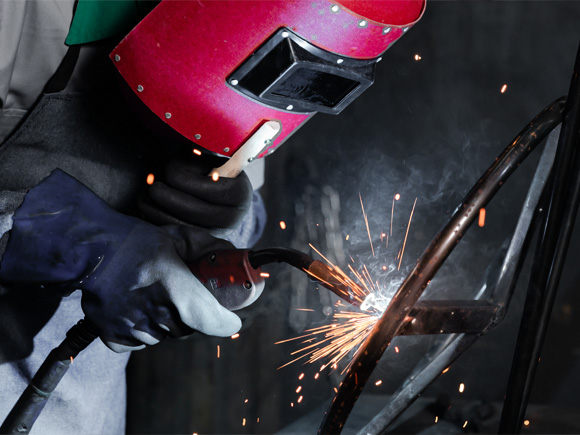 A worker is welding with helmet on