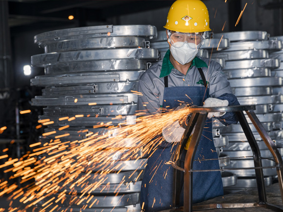 A male worker is cutting the metal stool leg