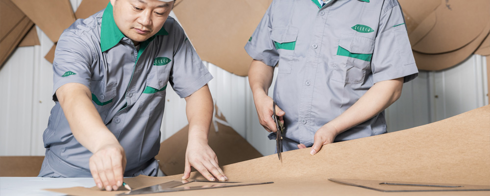 Several employees are measuring and cutting material