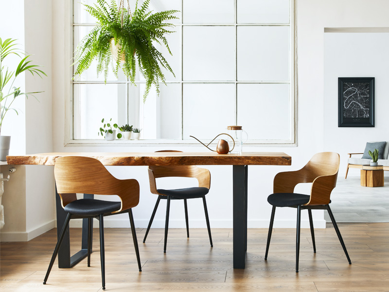 3 wooden chairs and a table in a room