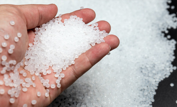 Hand holding plastic pellets