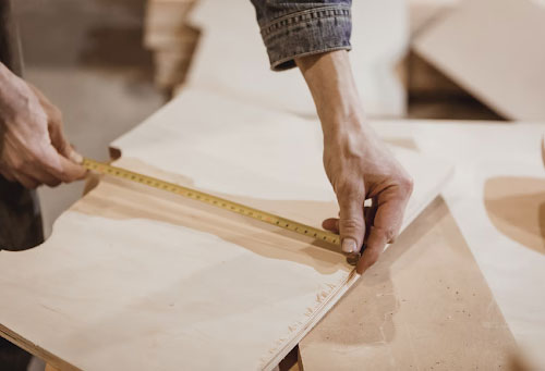 Person taking Measurements of wood