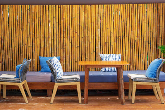 Wooden furniture with rattan chairs and bamboo wall stock photo