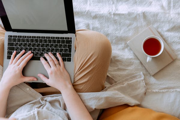 A person using a laptop with an empty screen