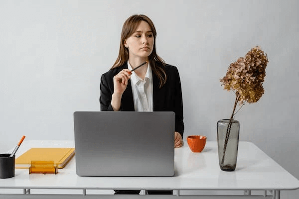 Woman in Black Blazer Sitting at the Table